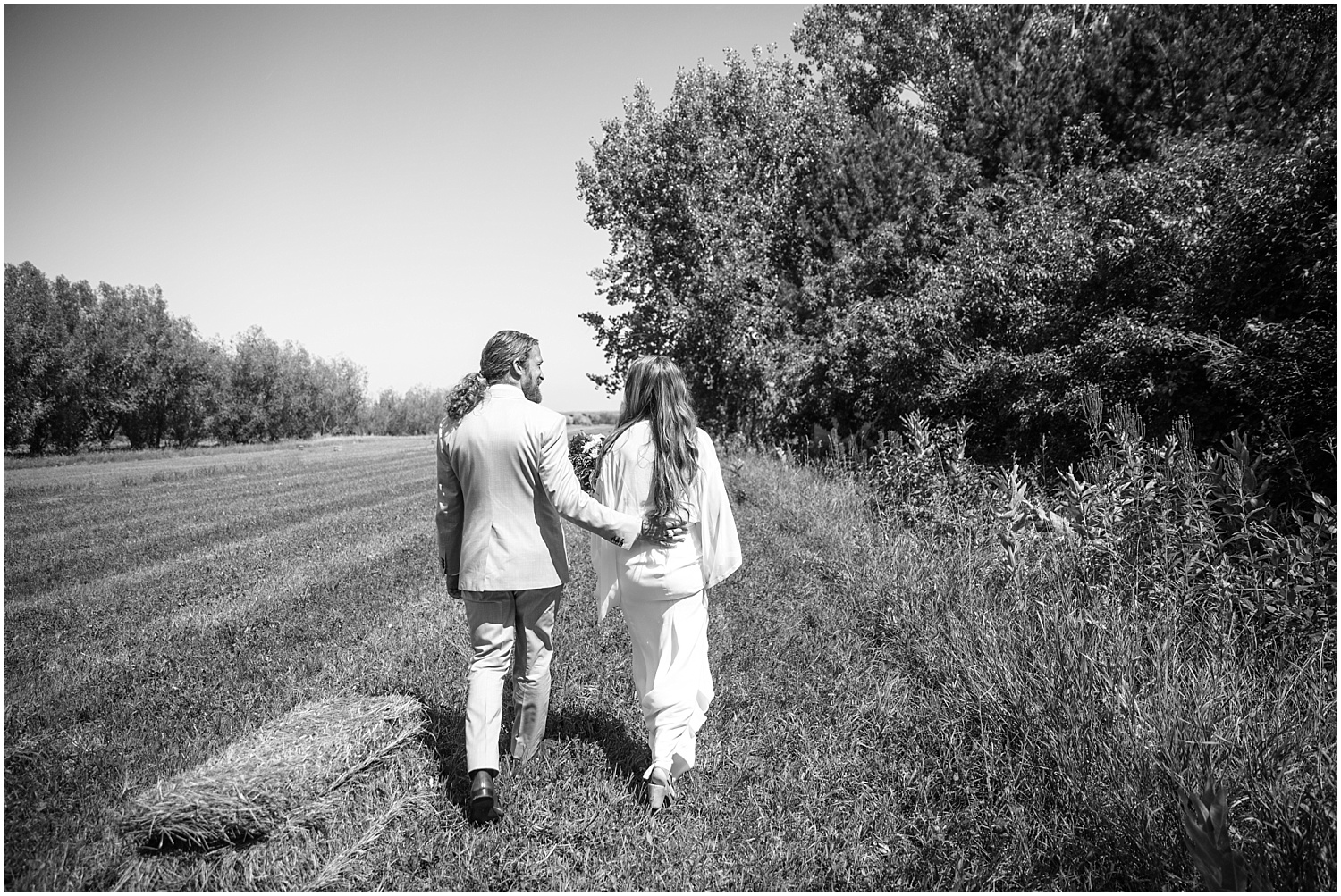 Bride and groom walk through the fields at Lone Hawk Farm in Longmont Colorado