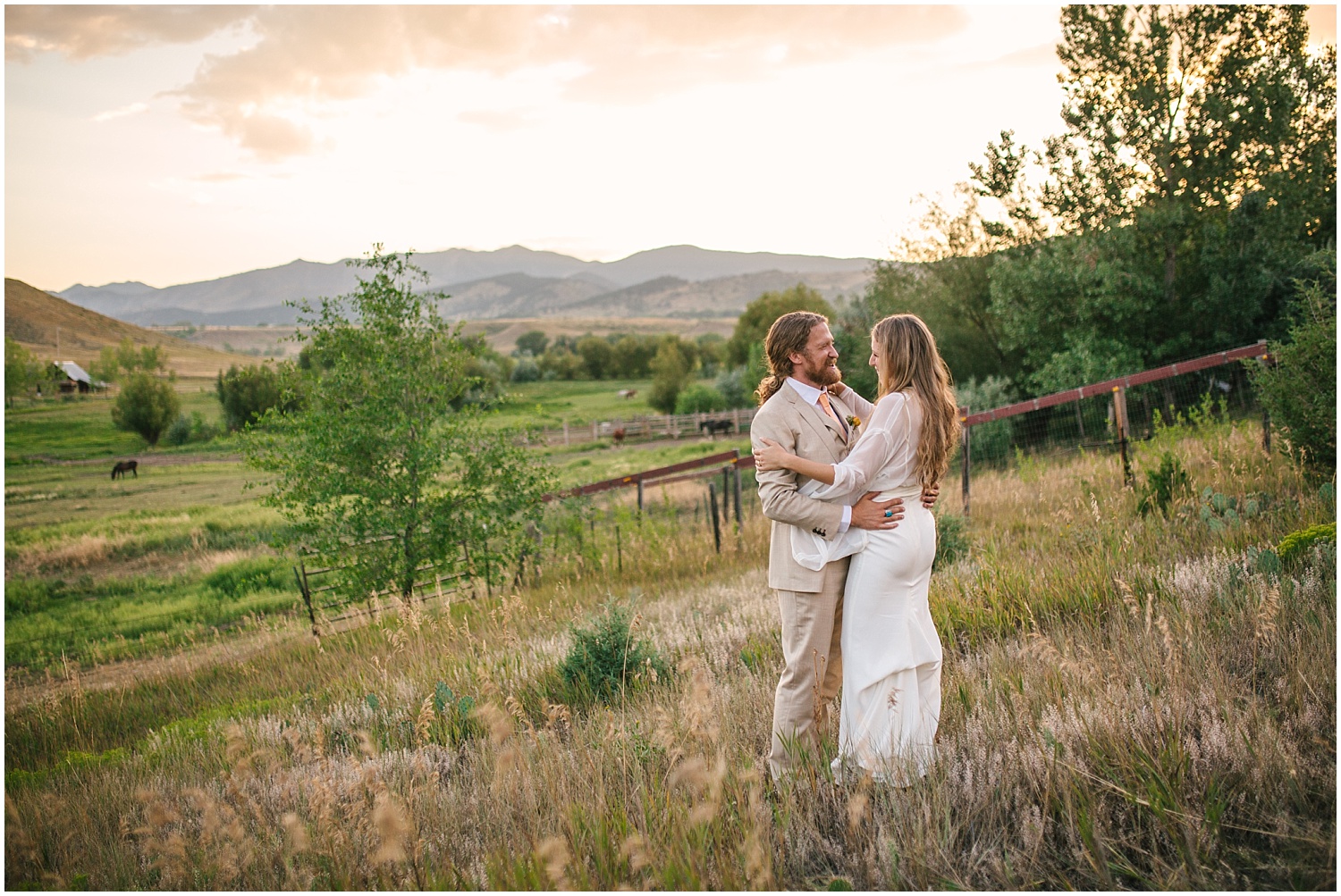 Bride and groom dancing on a hill overlooking the mountains at sunset at Lone Hawk Farm wedding in Longmont Colorado