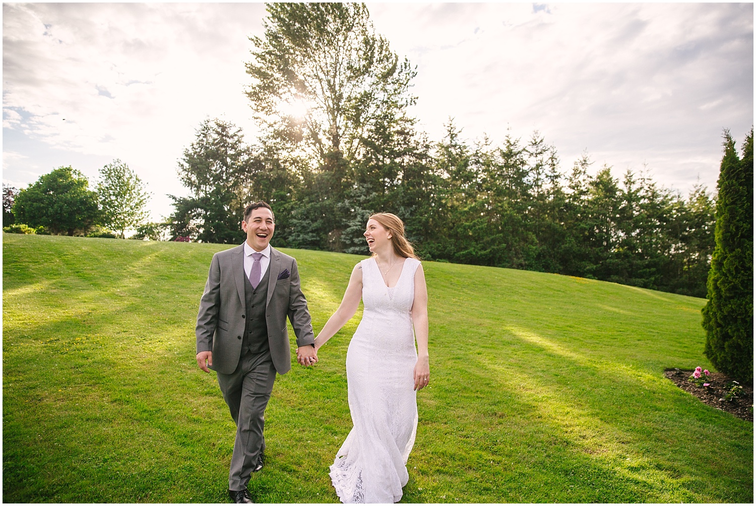 Bride and groom laughing walking down the grassy hill at Lord Hill Farms wedding