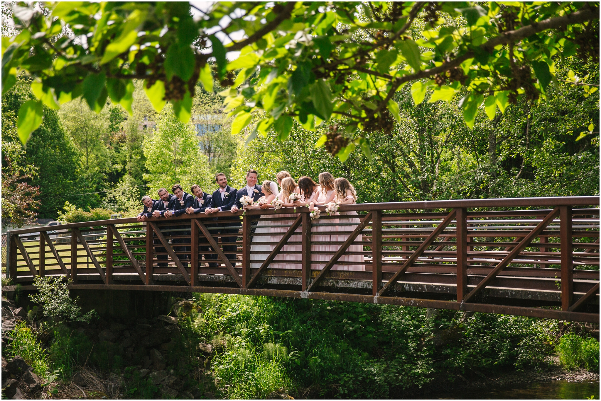 Wedding party stand on bridge at Issaquah Salmon Hatchery before Pickering Barn Wedding