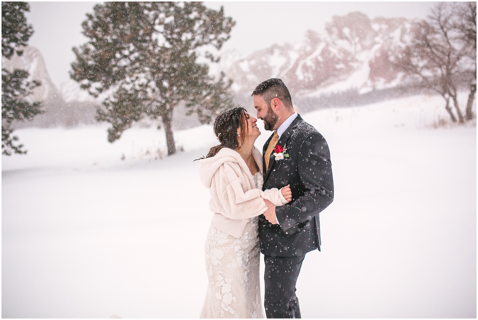 Bride and groom laughing in the snow at Arrowhead Golf Club winter wedding