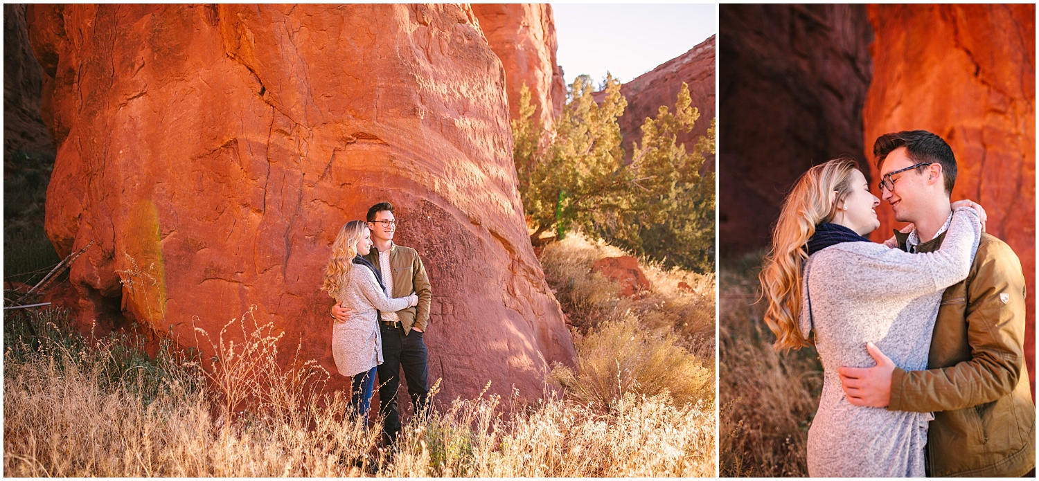 Couple kissing by red rocks in a field in Jemez New Mexico