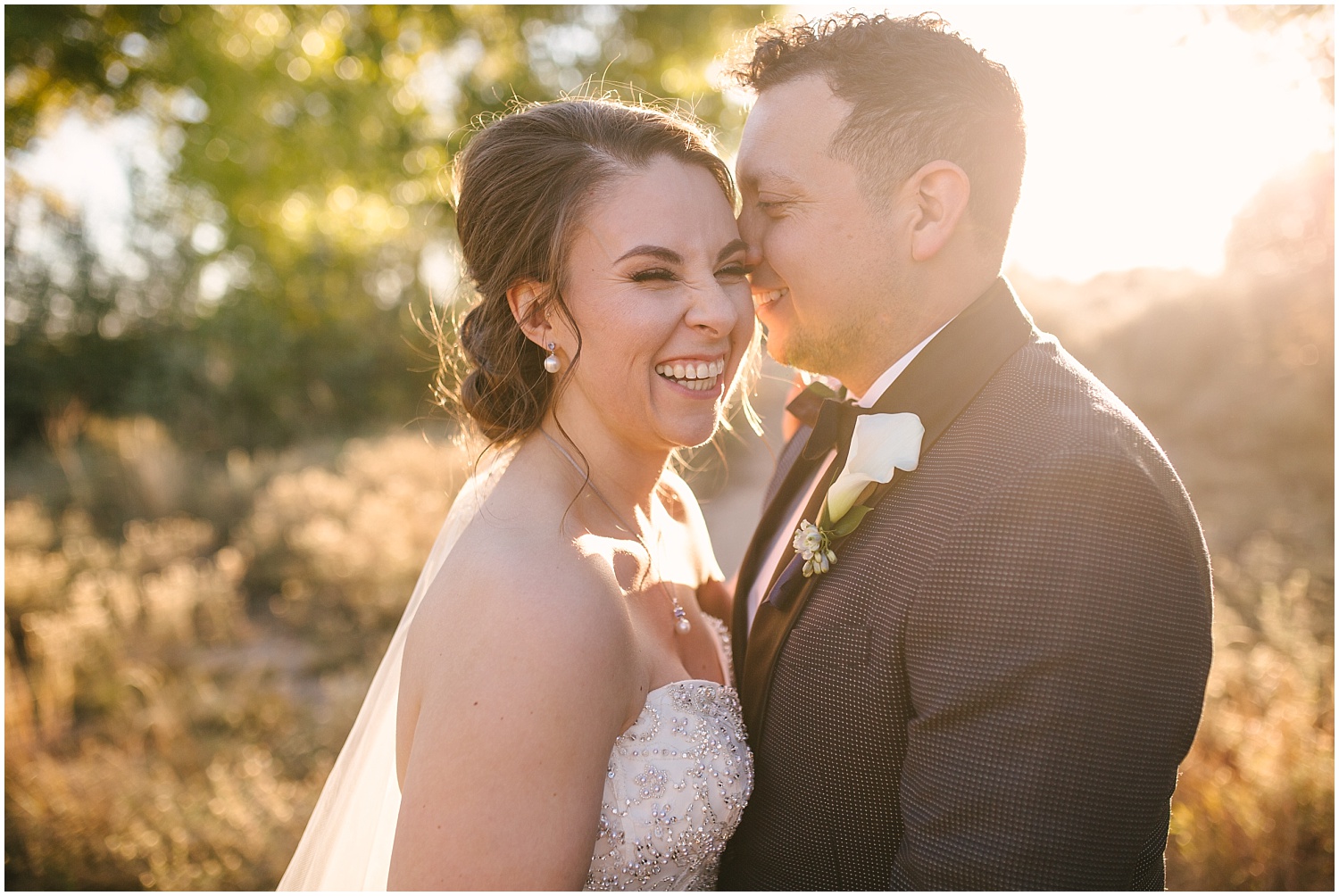 Bride and groom laughing together at golden hour at their fall wedding at Prairie Star Restaurant