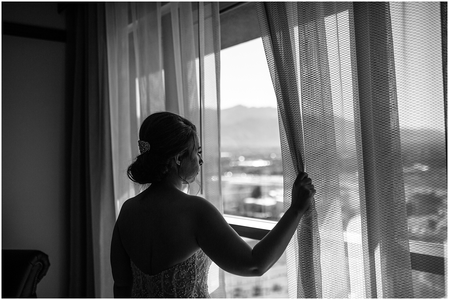 Bride looking at the mountains outside the window at Santa Ana Star Casino Hotel