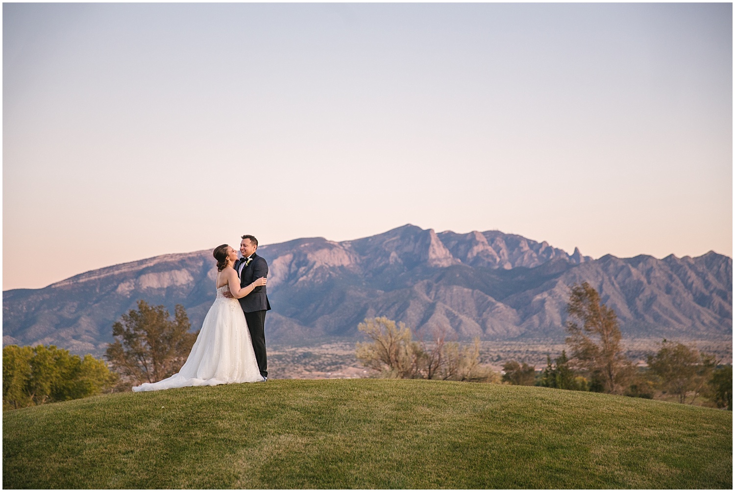 Bride and groom portraits in front of the Sandia Mountains at sunset at Prairie Star Restaurant wedding