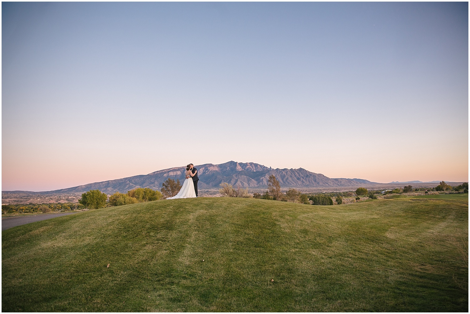 Bride and groom sunset portraits with Sandia Mountains on Santa Ana Golf Course at Prairie Star Restaurant wedding