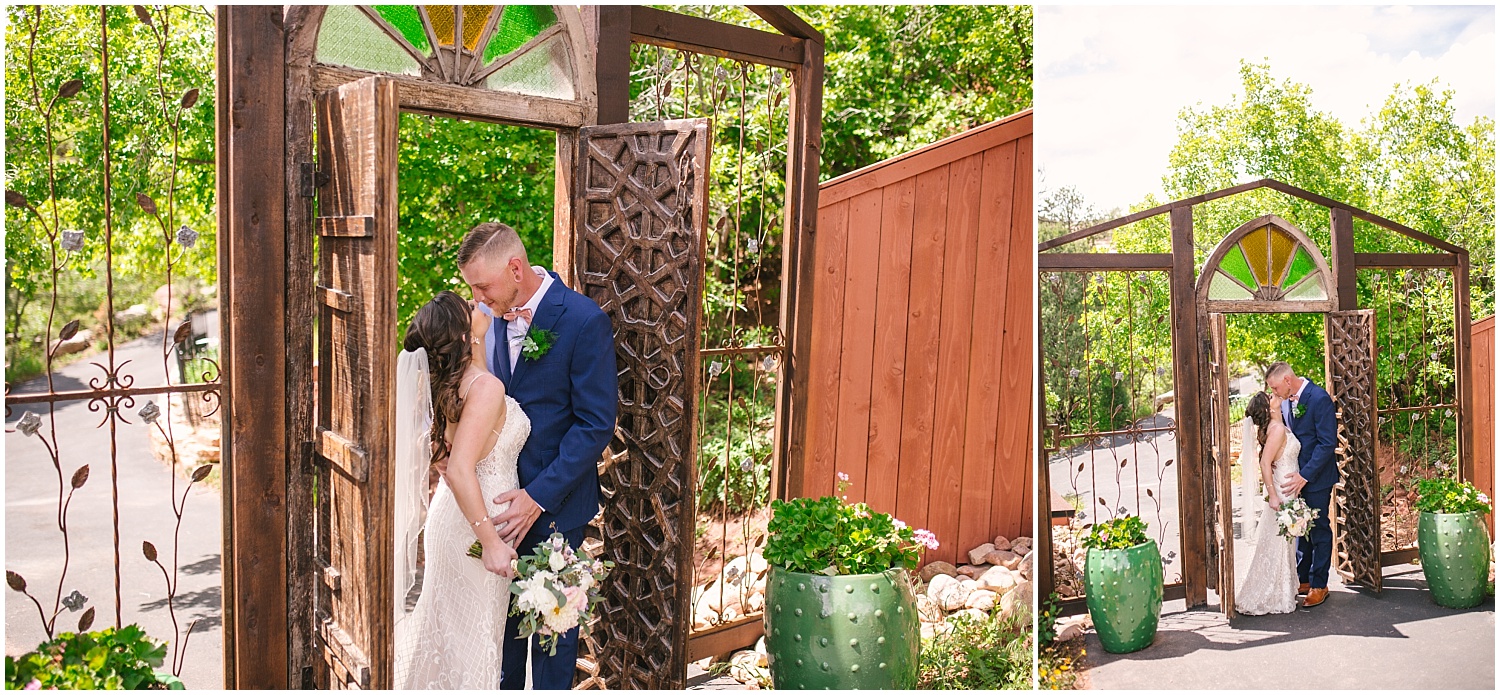 Bride and groom kissing under iconic gate with stained glass at Craftwood Inn in Manitou Springs