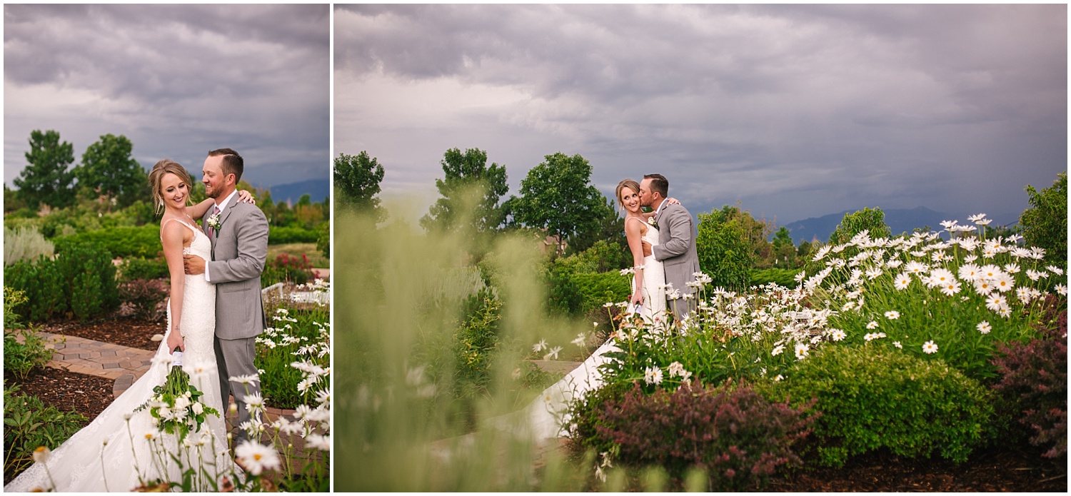 Bride and groom embrace in a garden under storm clouds at Cordera in Colorado Springs