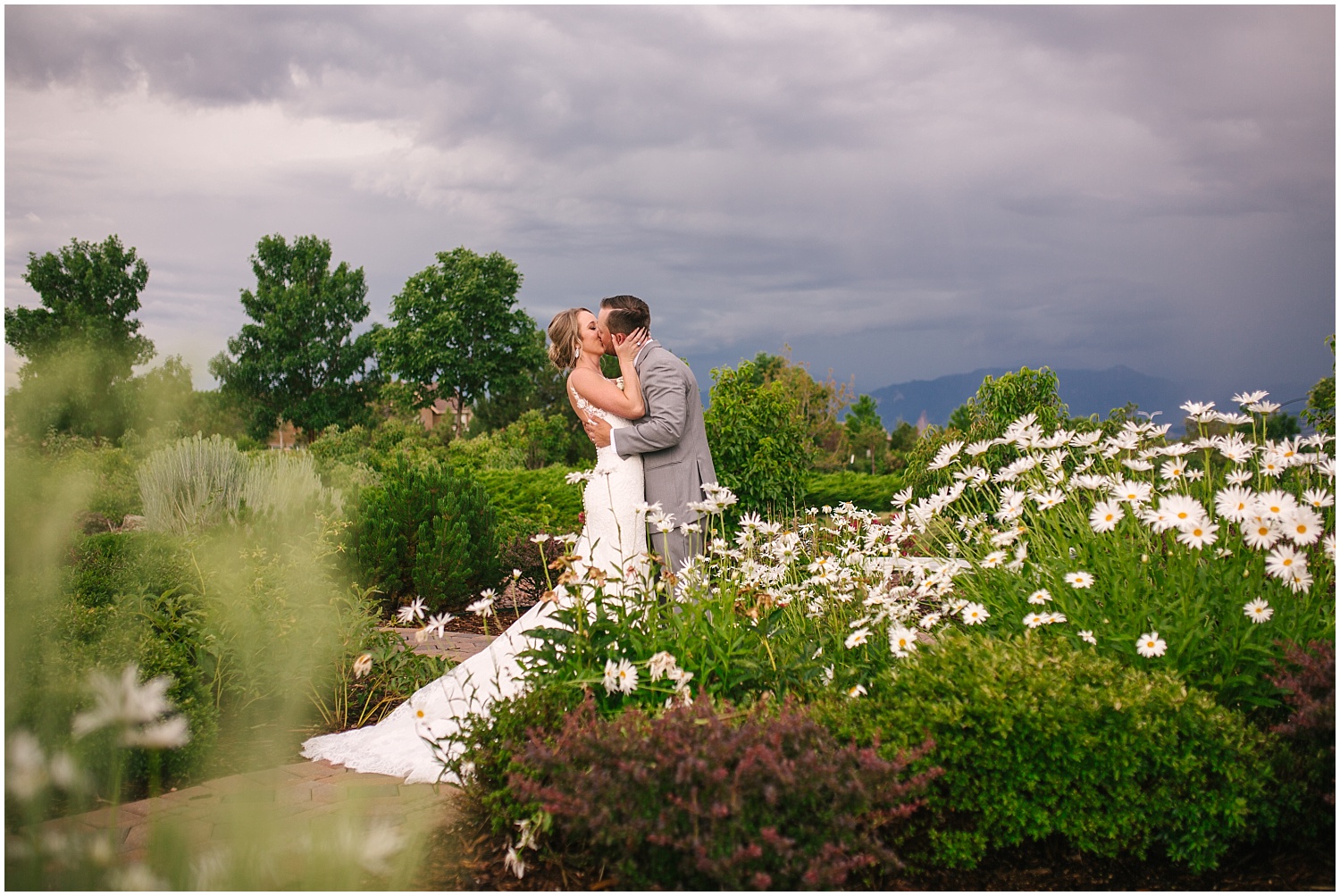 Bride and groom kissing in a garden during stormy summer wedding in Colorado Springs