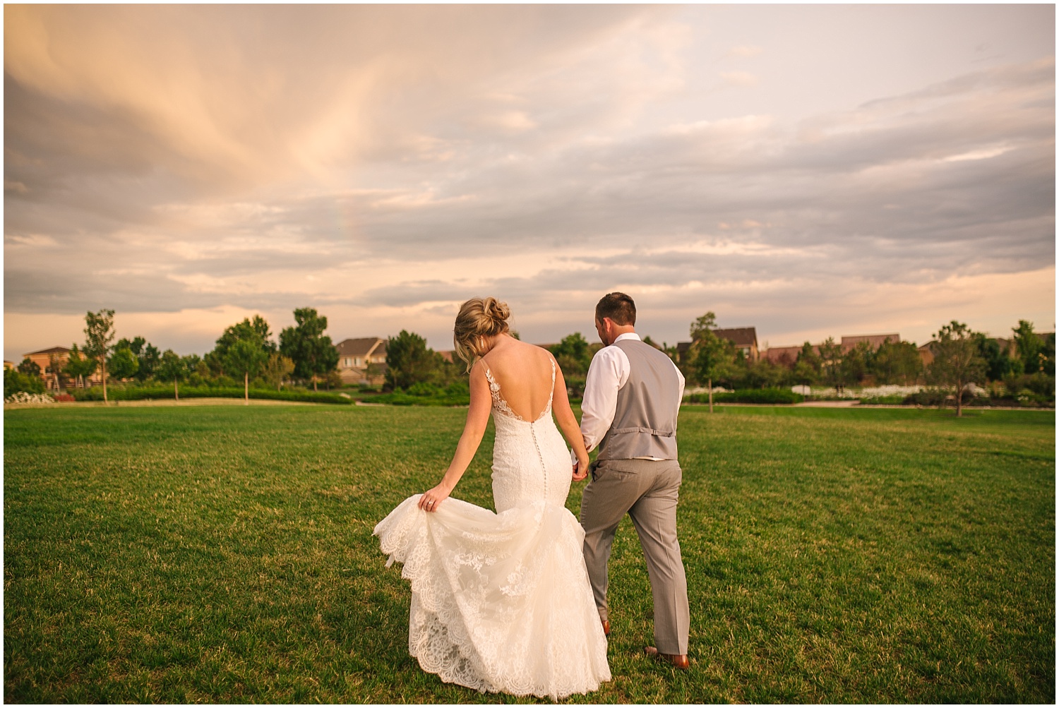 Bride and groom walk together up a hill at sunset in Colorado Springs