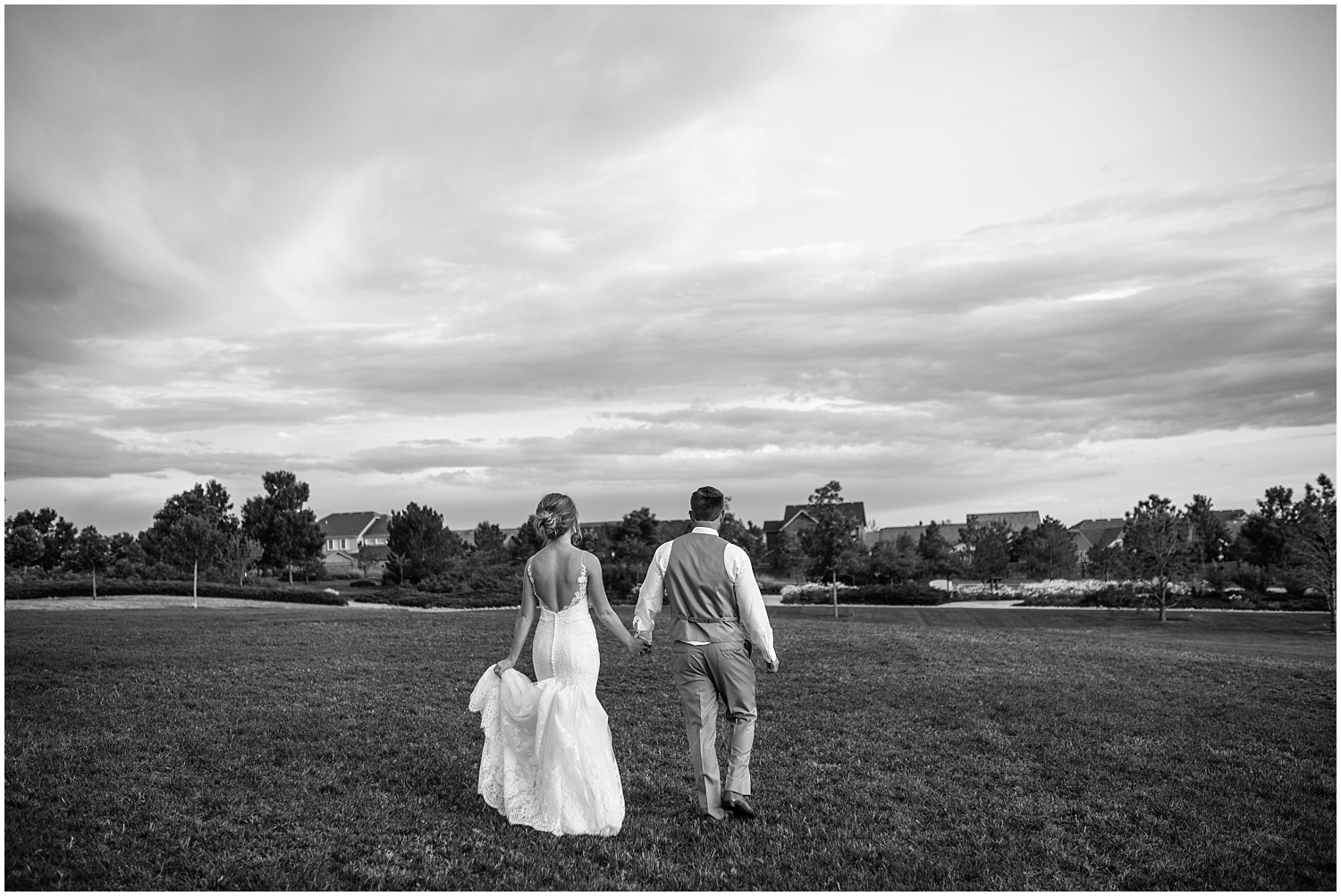 Bride and groom walking together at stormy summer wedding in Colorado Springs
