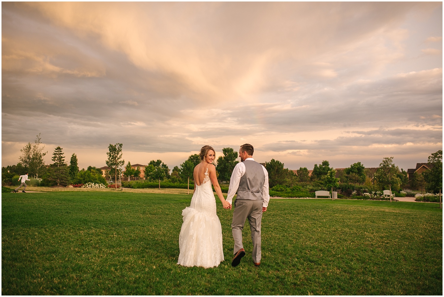 Bride and groom walking together at sunset in Colorado Springs during stormy summer wedding