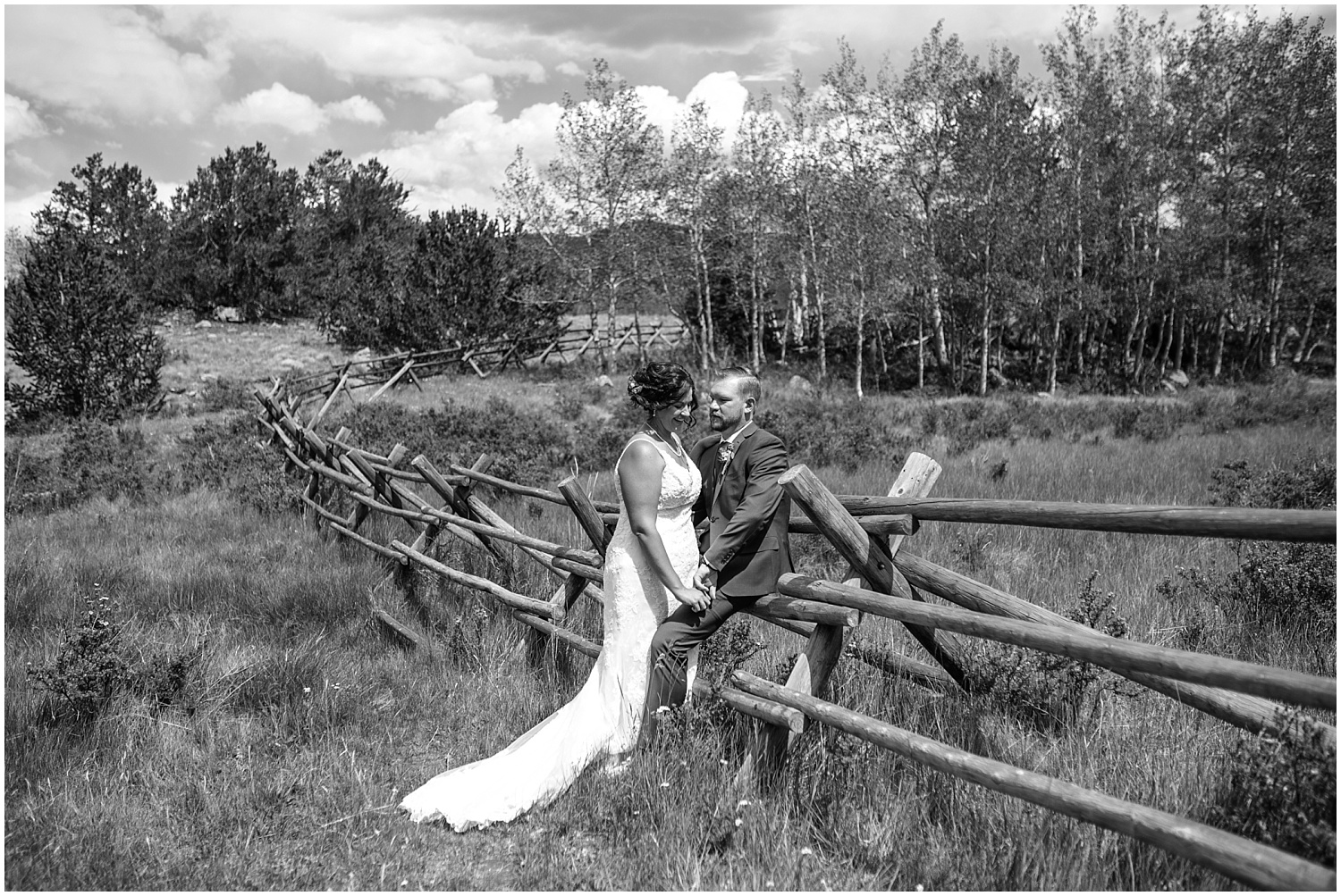 Bride and groom leaning on wooden fence in Kenosha Pass Colorado