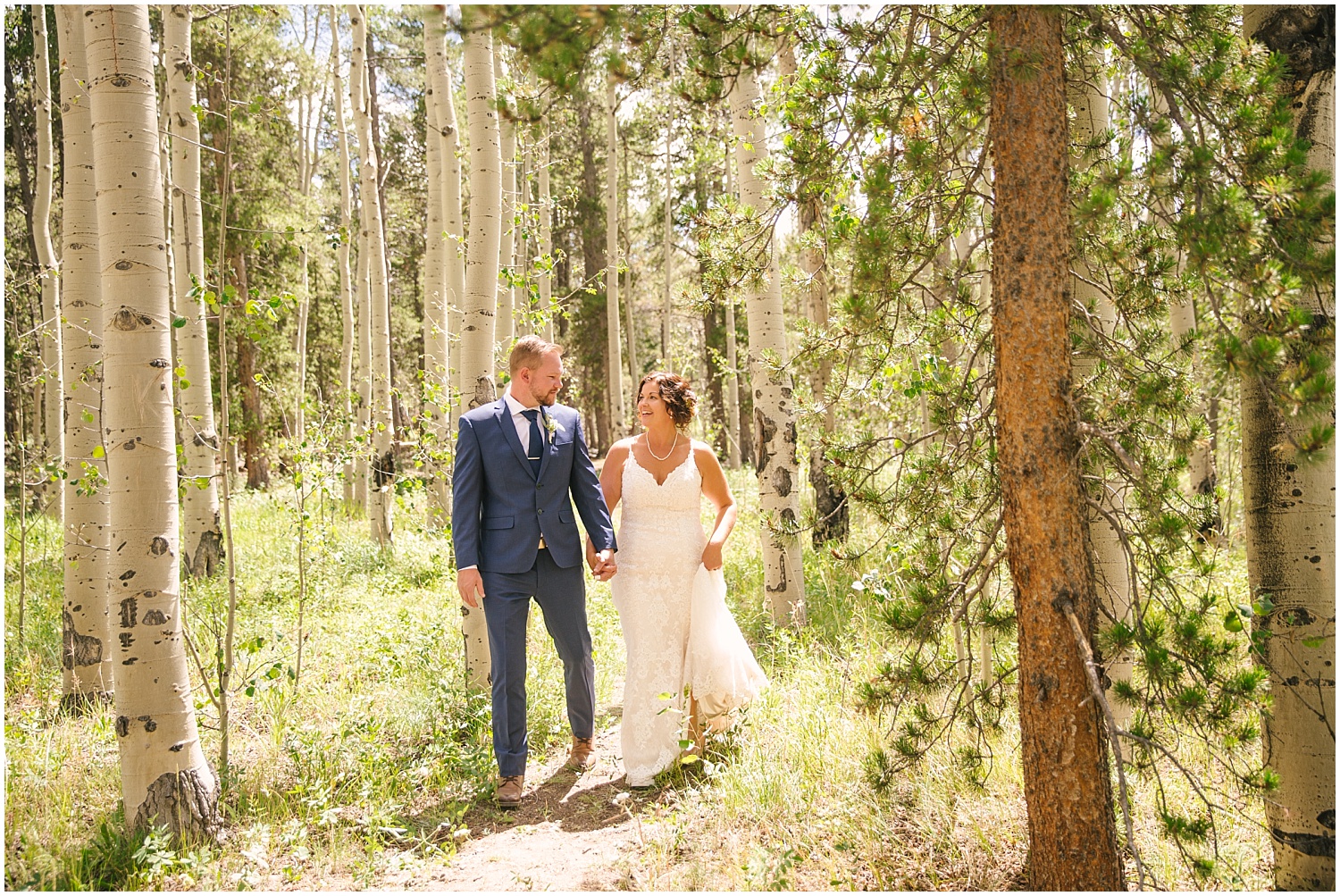 Bride and groom surrounded by bright green aspen trees for summer Colorado wedding