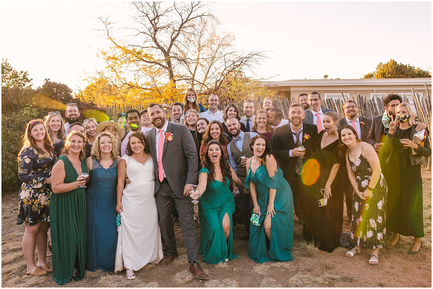 Bride and groom with all their friends at sunset backyard wedding reception