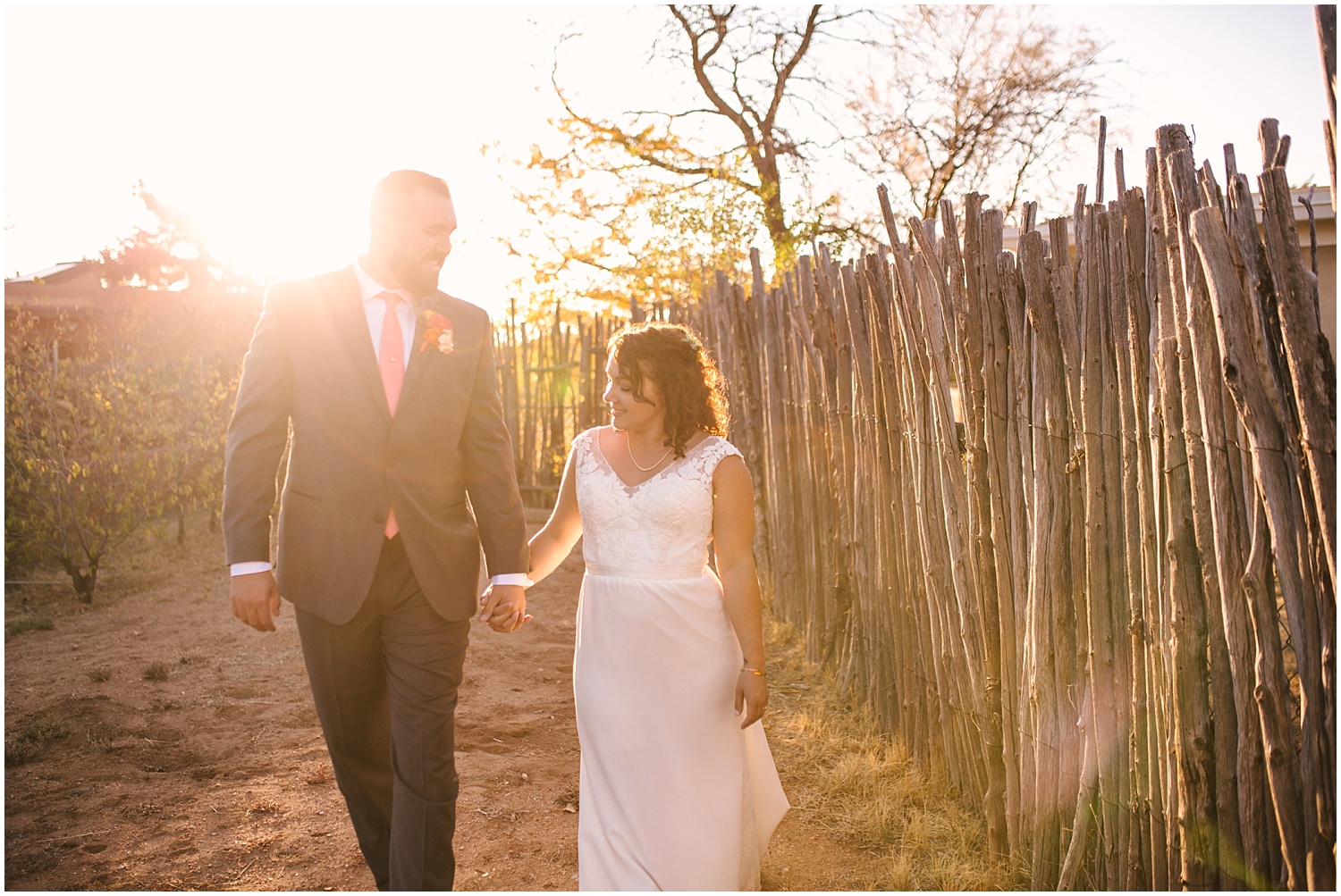 bride and groom walking in the golden sunlight at backyard wedding in Santa Fe