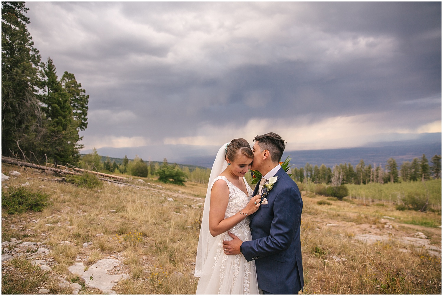 Groom whispers secrets to his bride on the side of the Sandia Mountains outside Albuquerque