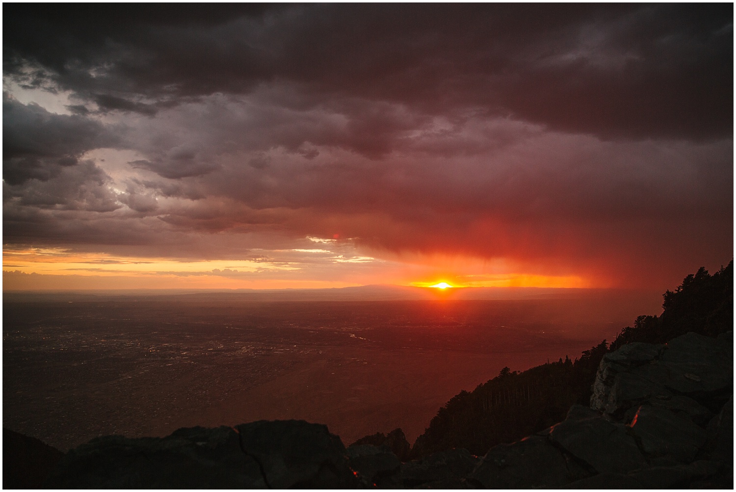 sun setting over Albuquerque from Sandia Crest after a heavy thunderstorm