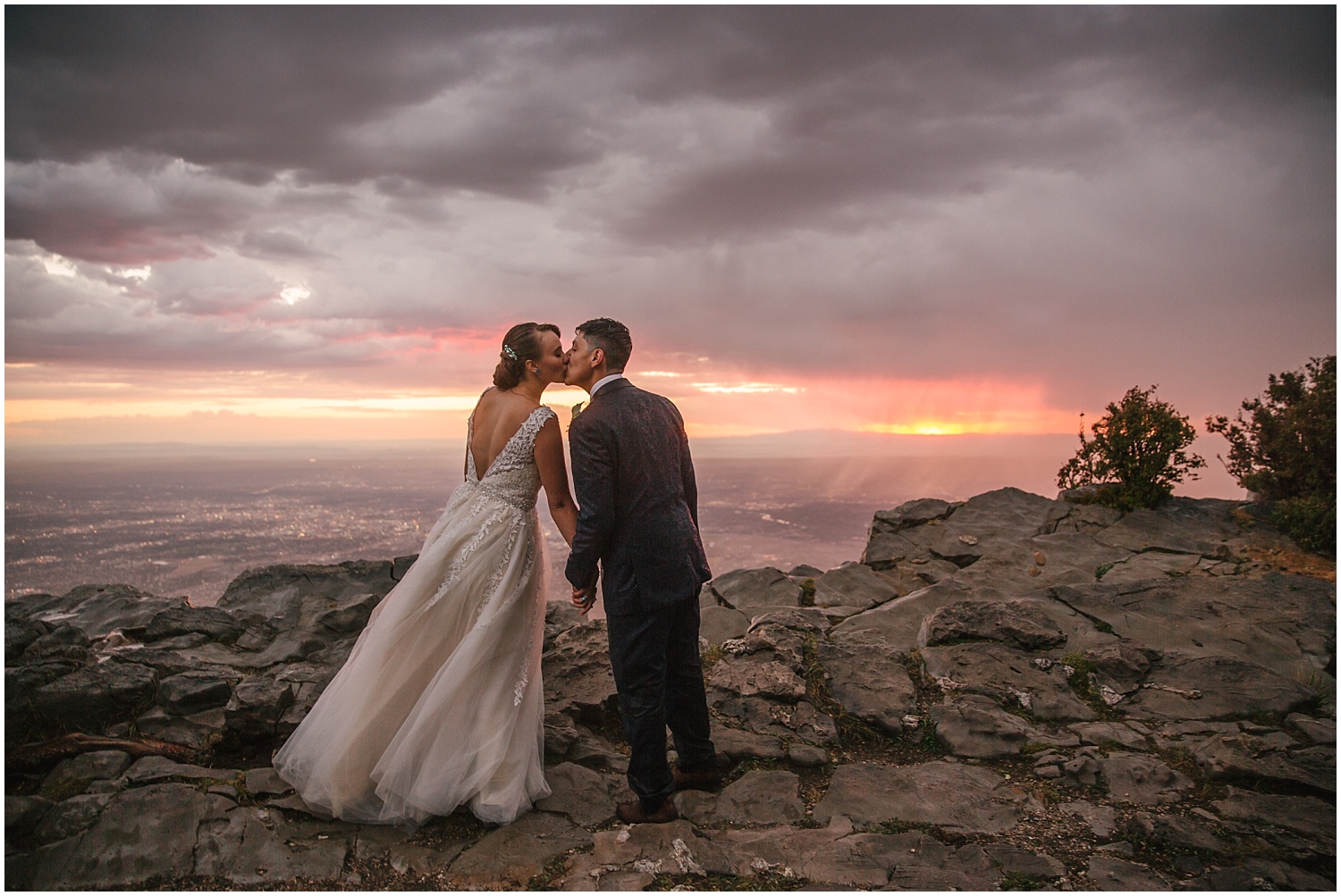 Bride and groom kissing at the top of Sandia Crest at sunset