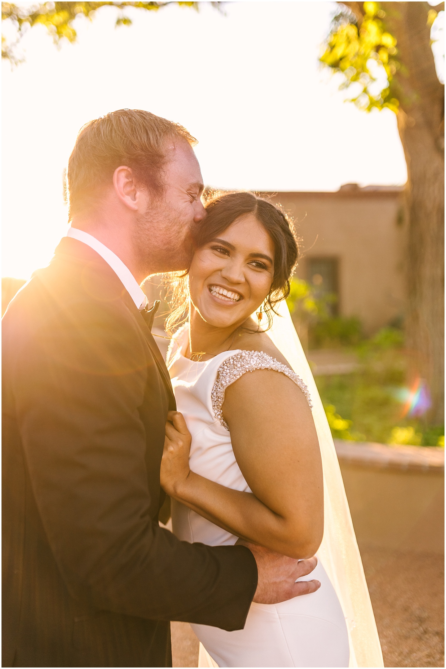 Groom kissing his bride at golden hour in New Mexico wedding