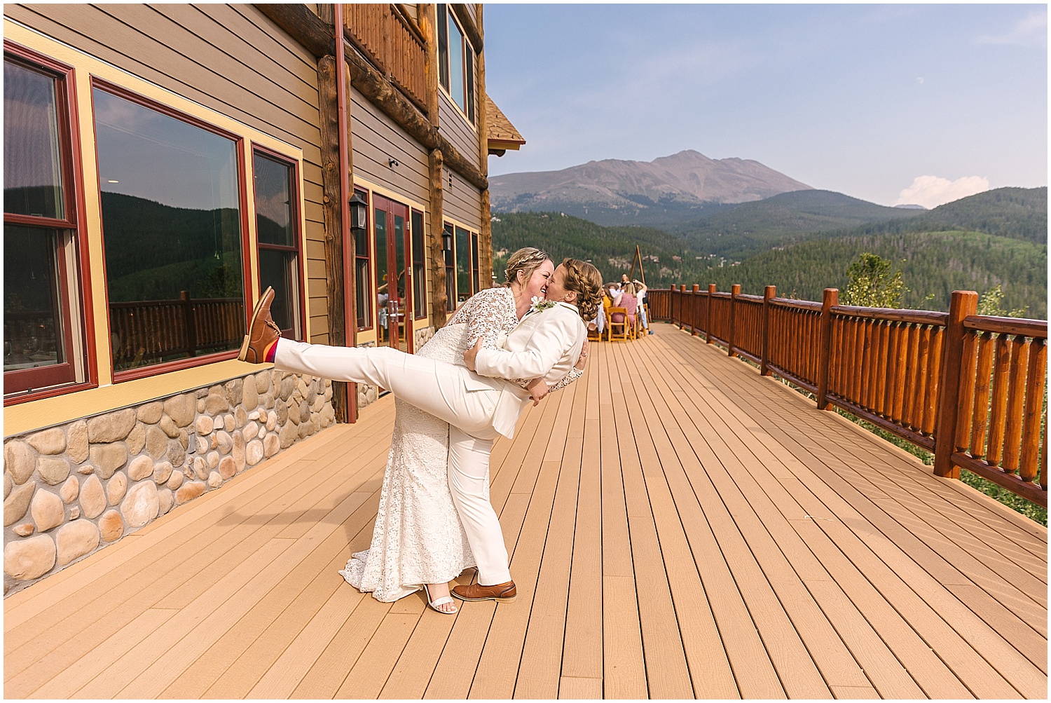 Bride dips her bride for a kiss on the deck at the Lodge at Breckenridge