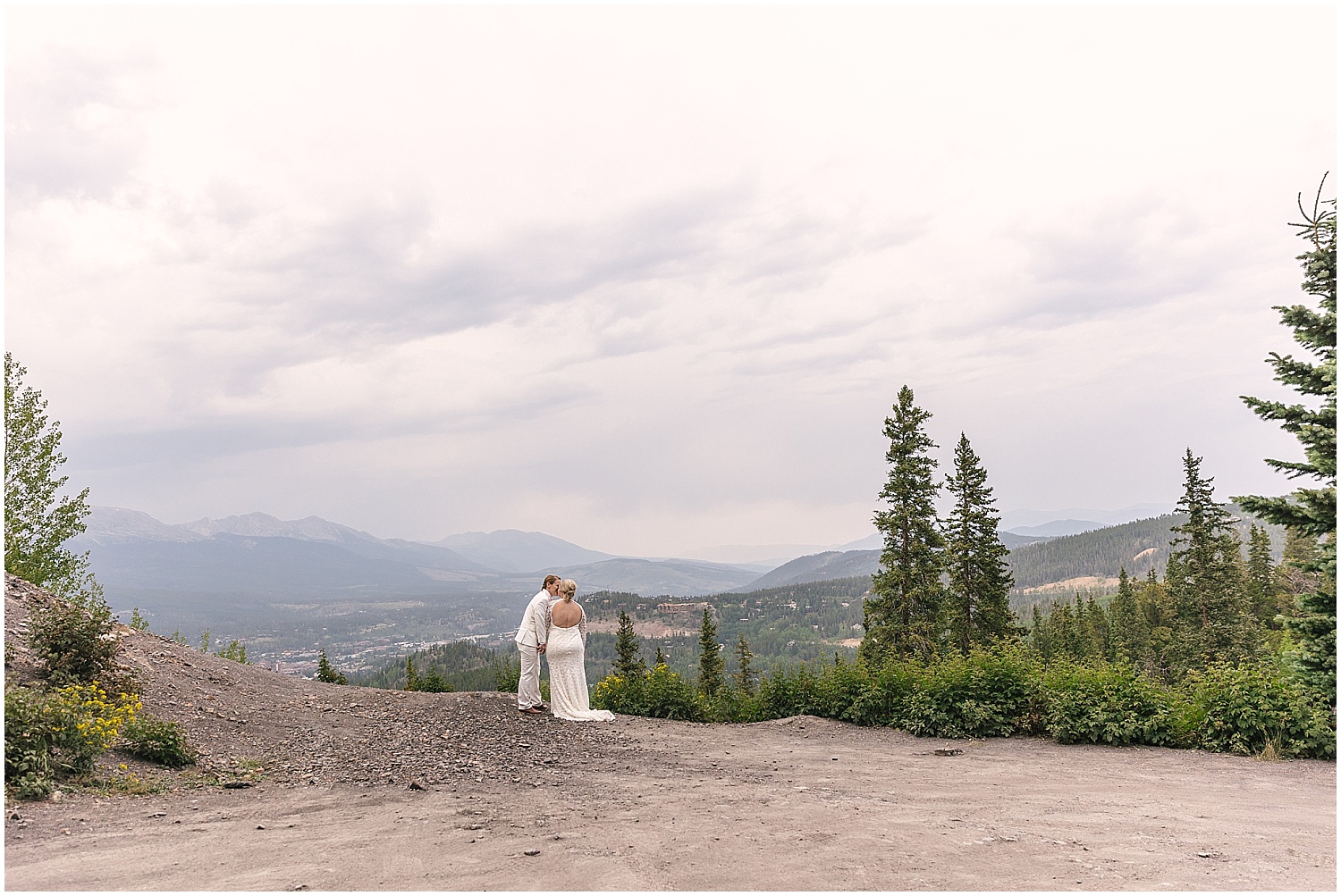 Two brides kissing at an overlook in Breckenridge, Colorado