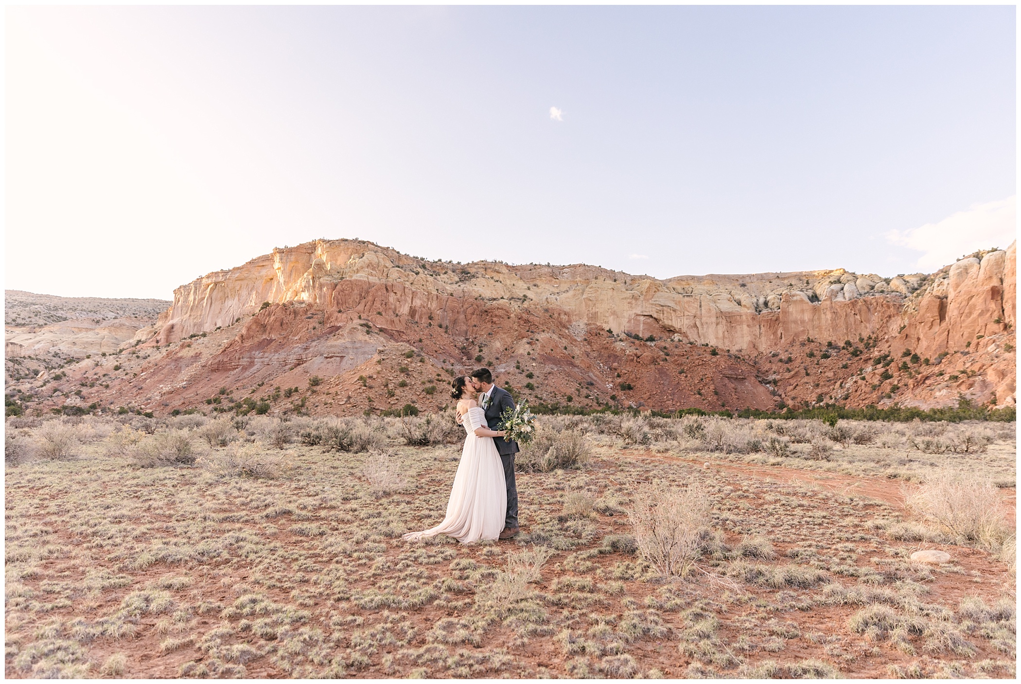 bride and groom kissing at sunset in Ghost Ranch New Mexico