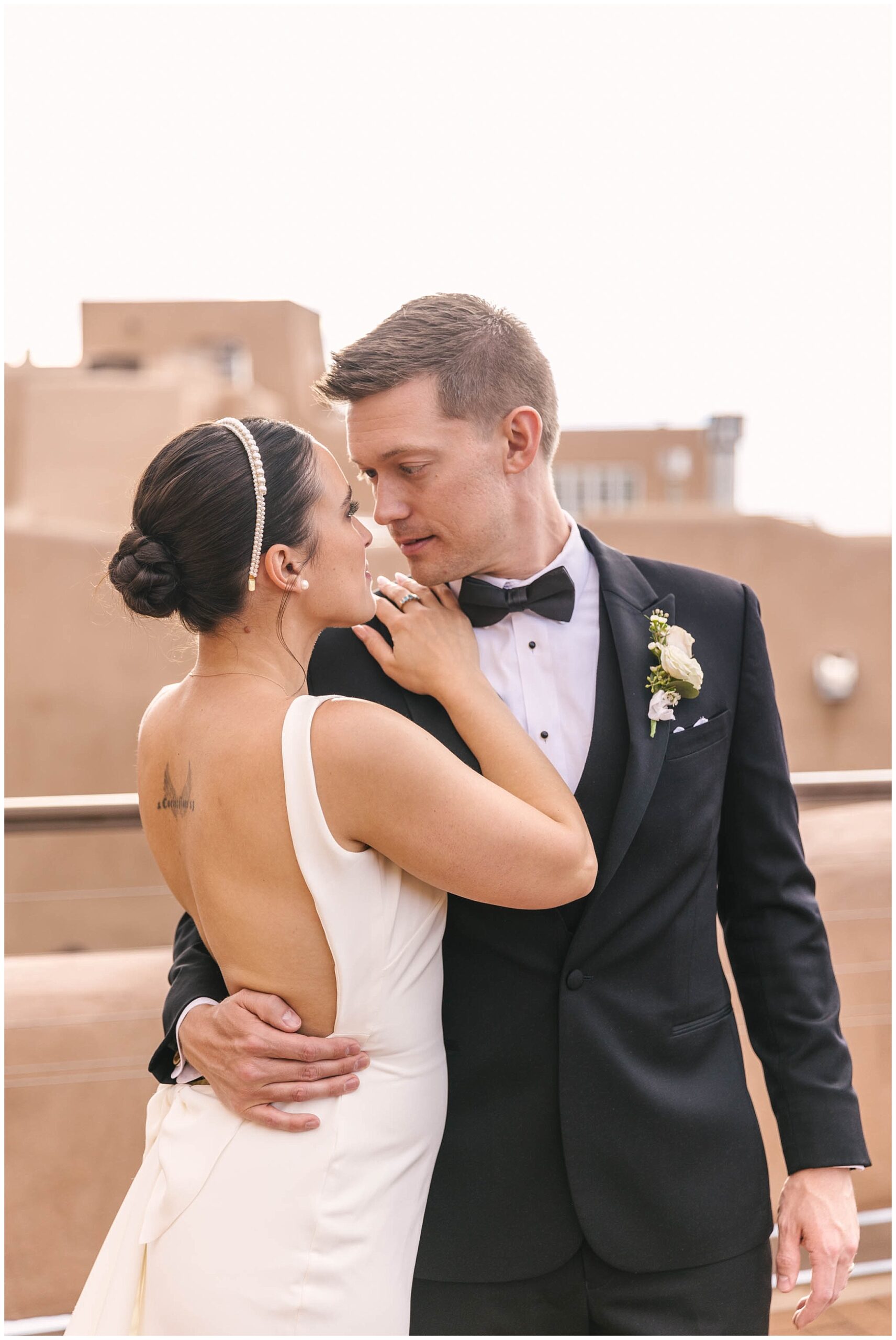 Classic and chic bride and groom portraits on adobe rooftop at La Fonda on the Plaza wedding in Santa Fe New Mexico