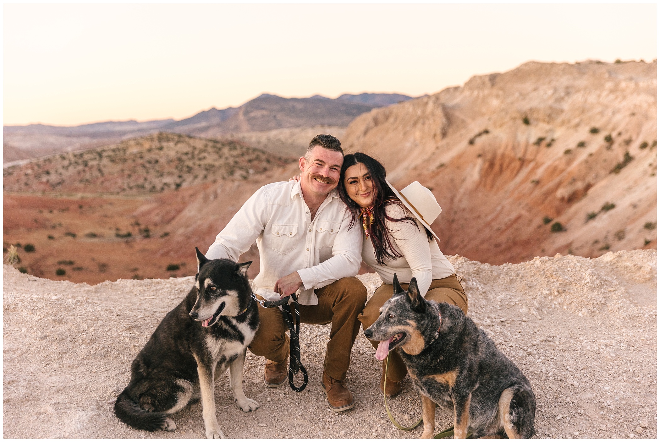 White Ridge engagement photo with two dogs at sunset in New Mexico desert