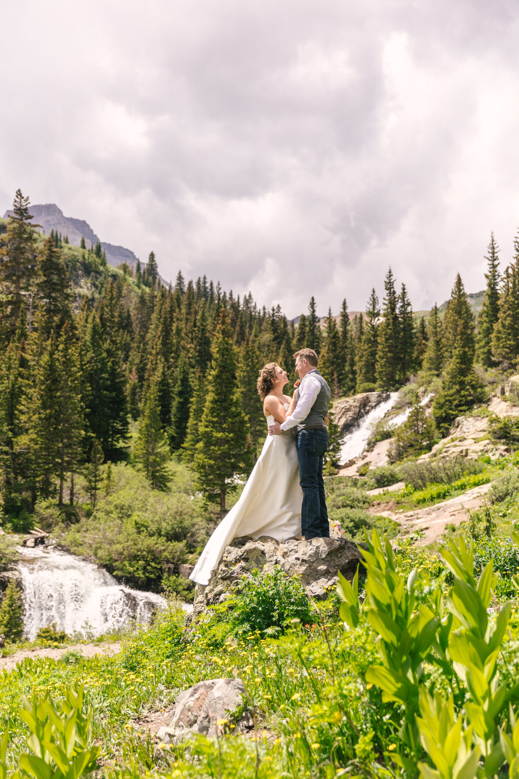 bride and groom by waterfall in Ouray, Colorado