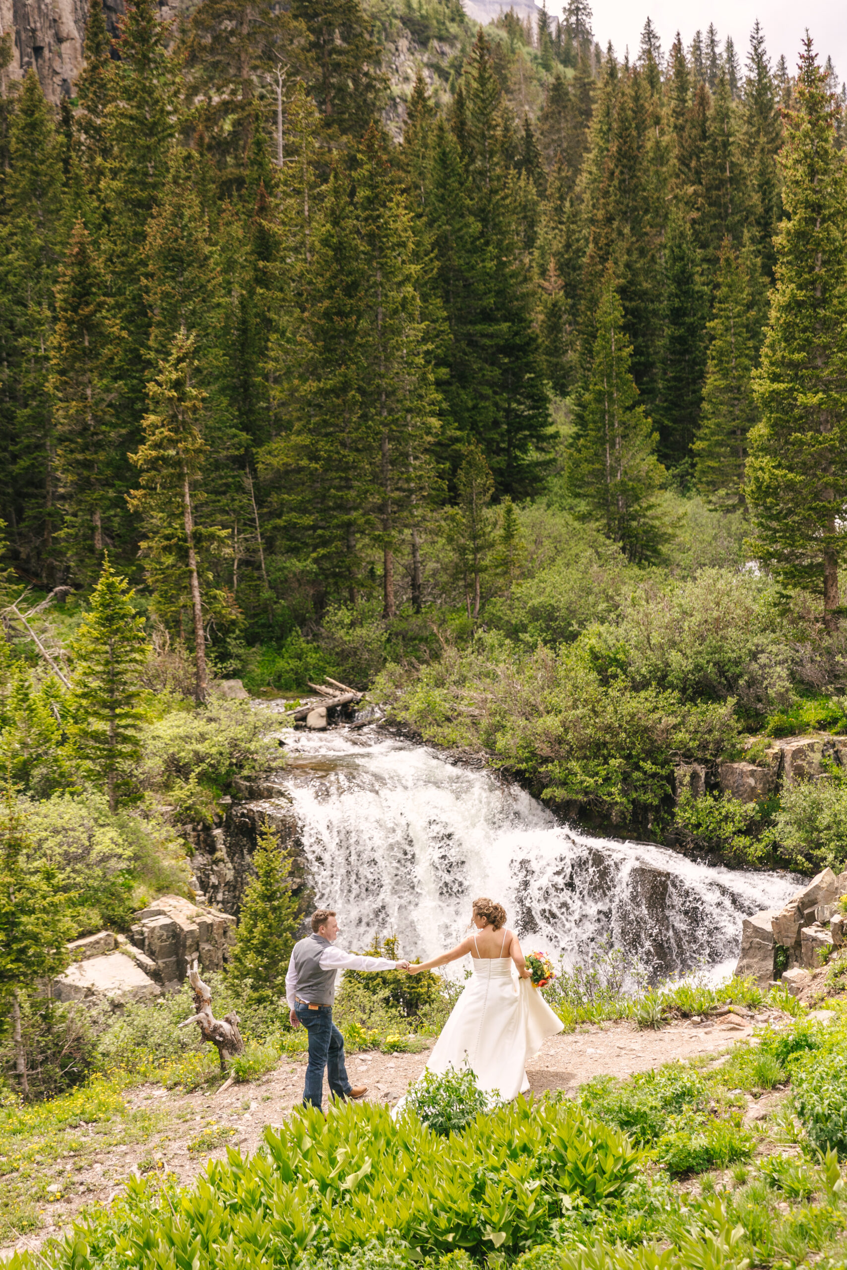 bride and groom dancing in front of waterfall in Ouray Colorado adventure elopement