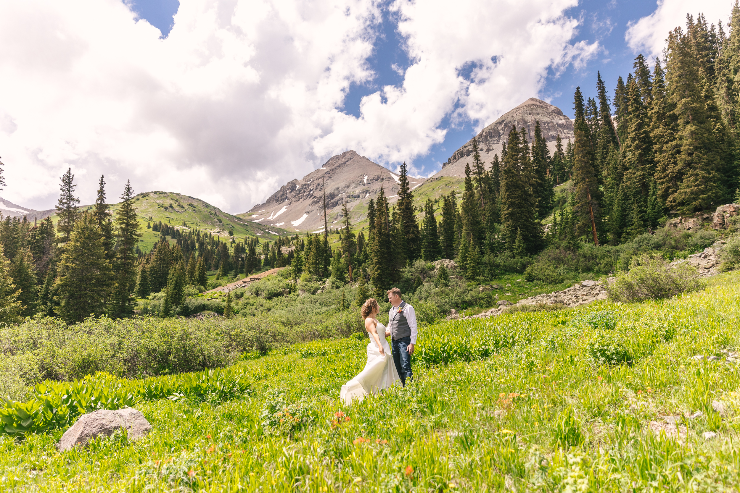 bride and groom portraits in green field of wildflowers for summer Ouray Colorado adventure elopement