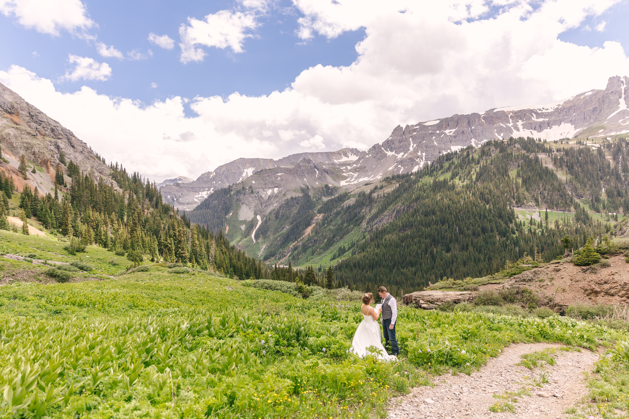 couple reading each other vows during intimate elopement in a field in the Colorado mountains