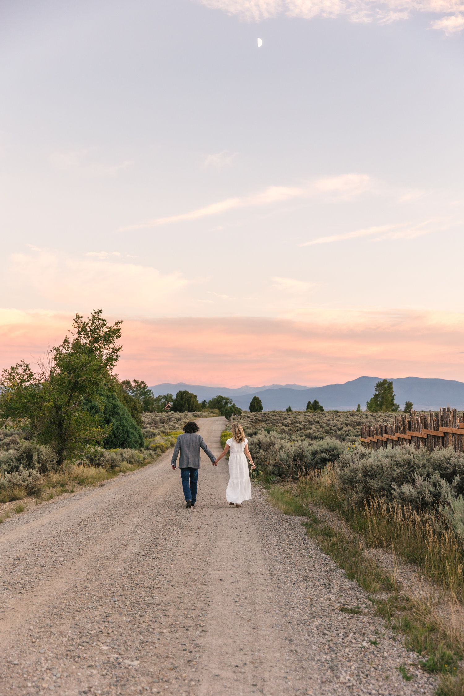 bride and groom walking into the sunset in Taos New Mexico