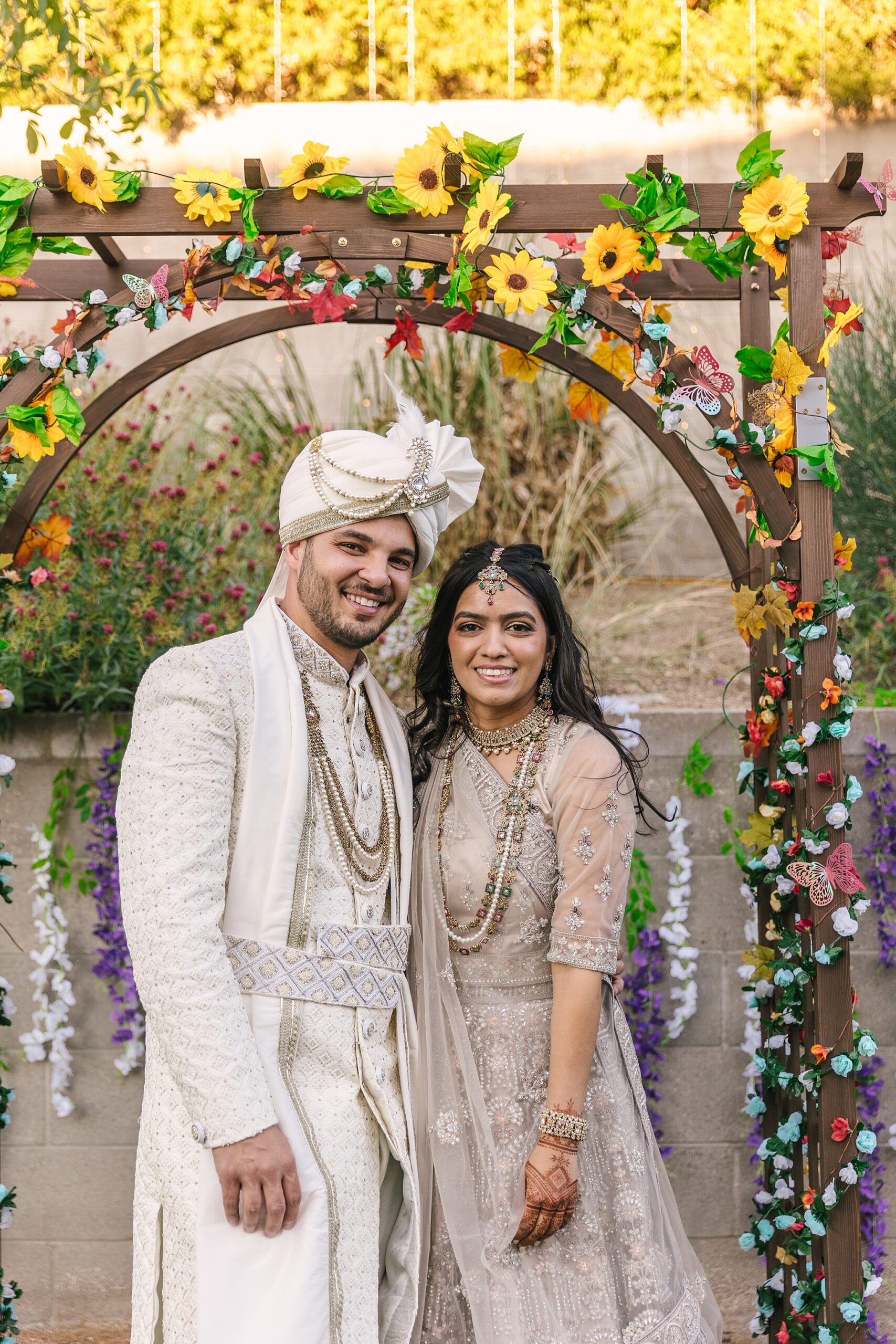 bride and groom with Indian backyard wedding arch