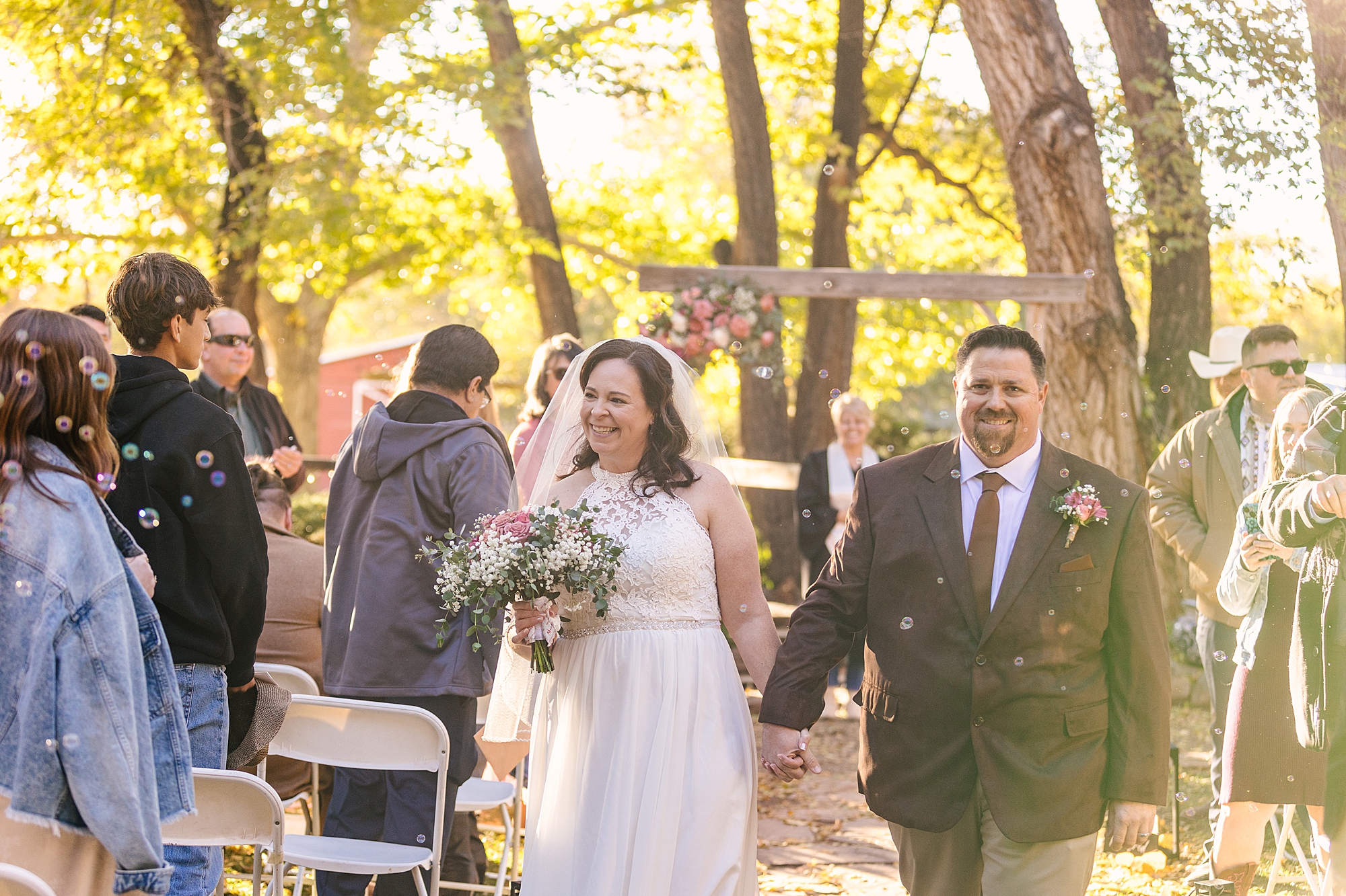 bride and groom walking up aisle in sunshine at Old Town Farm wedding