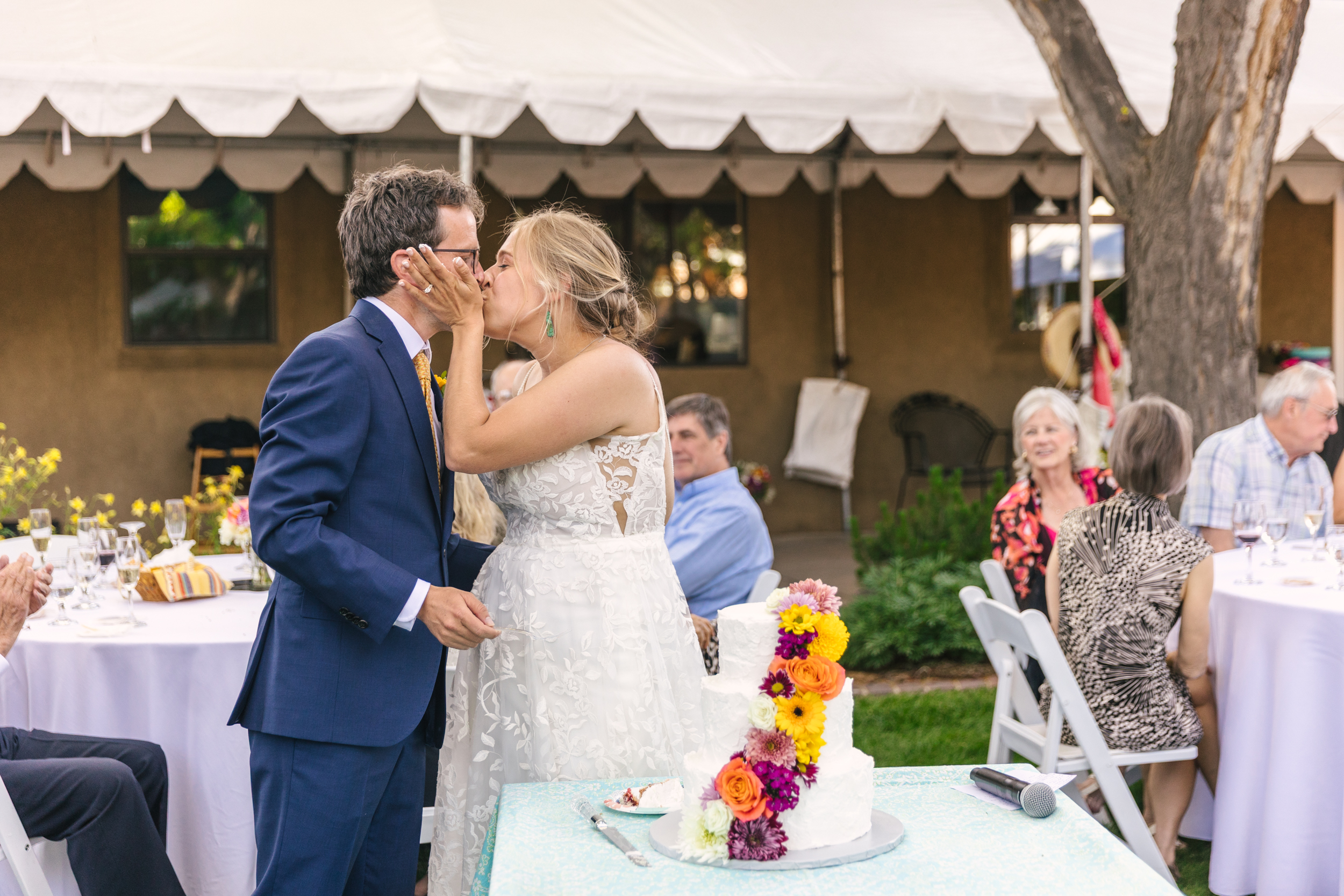 bride and groom cutting the cake at vibrant backyard wedding