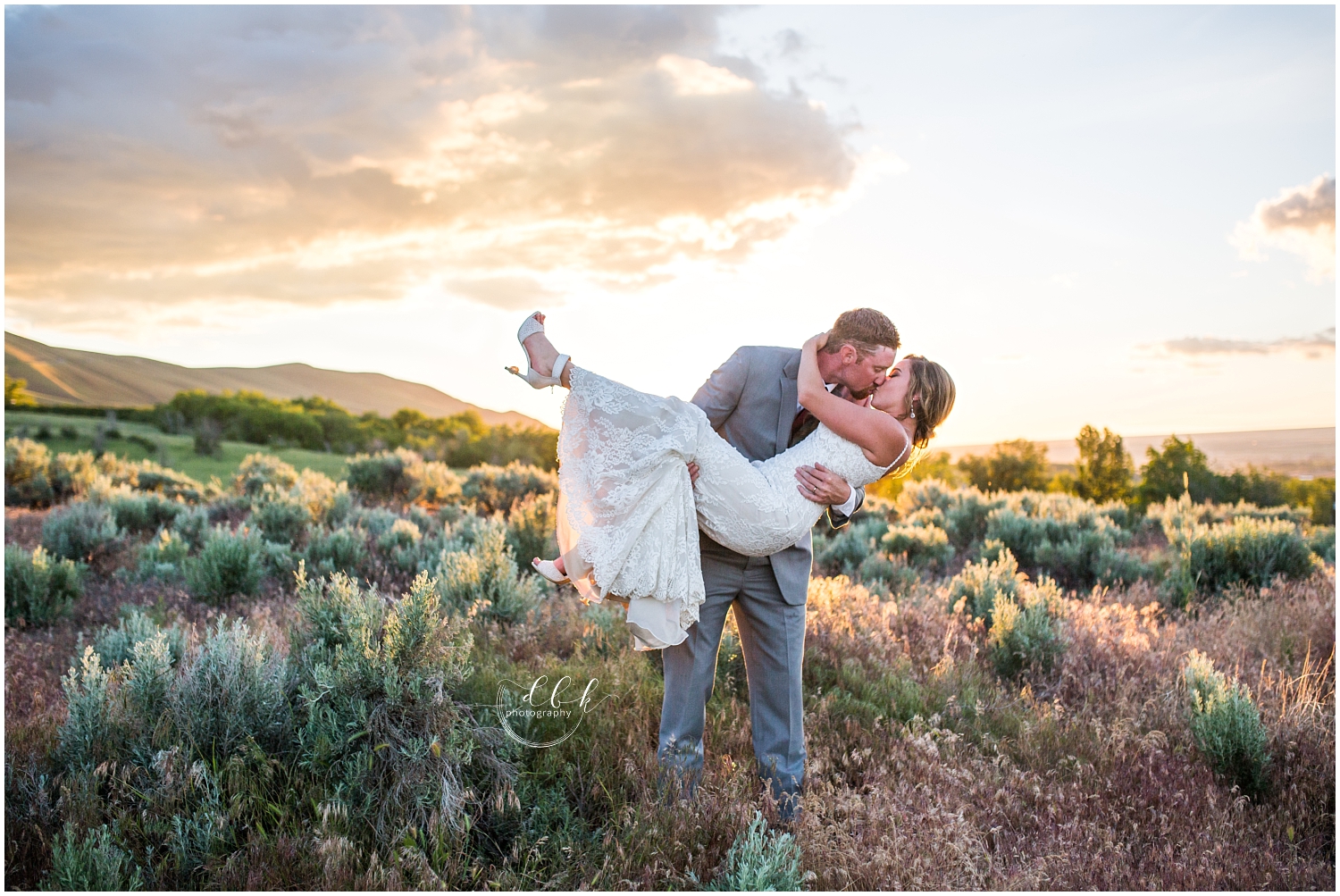 groom carrying his bride and kissing her at sunset in eastern Washington
