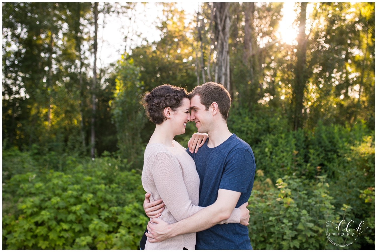 beautiful backlit portrait of couple standing with their foreheads together at Juanita Bay Park, Kirkland
