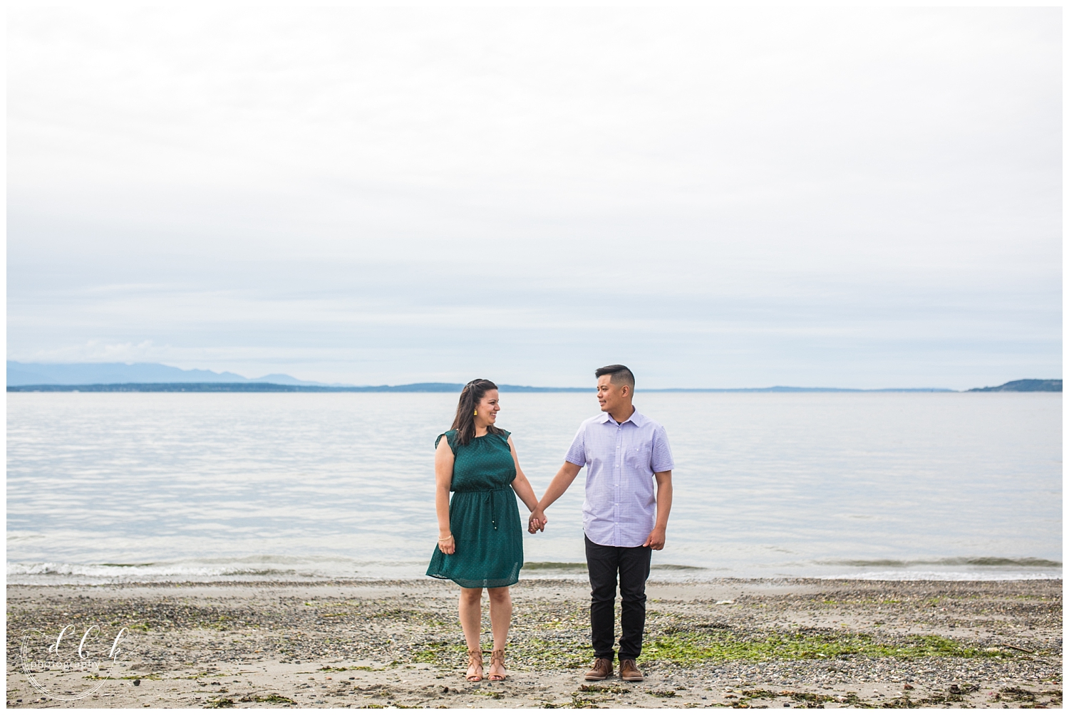 couple holding hands for engagement picture at Alki Beach in West Seattle