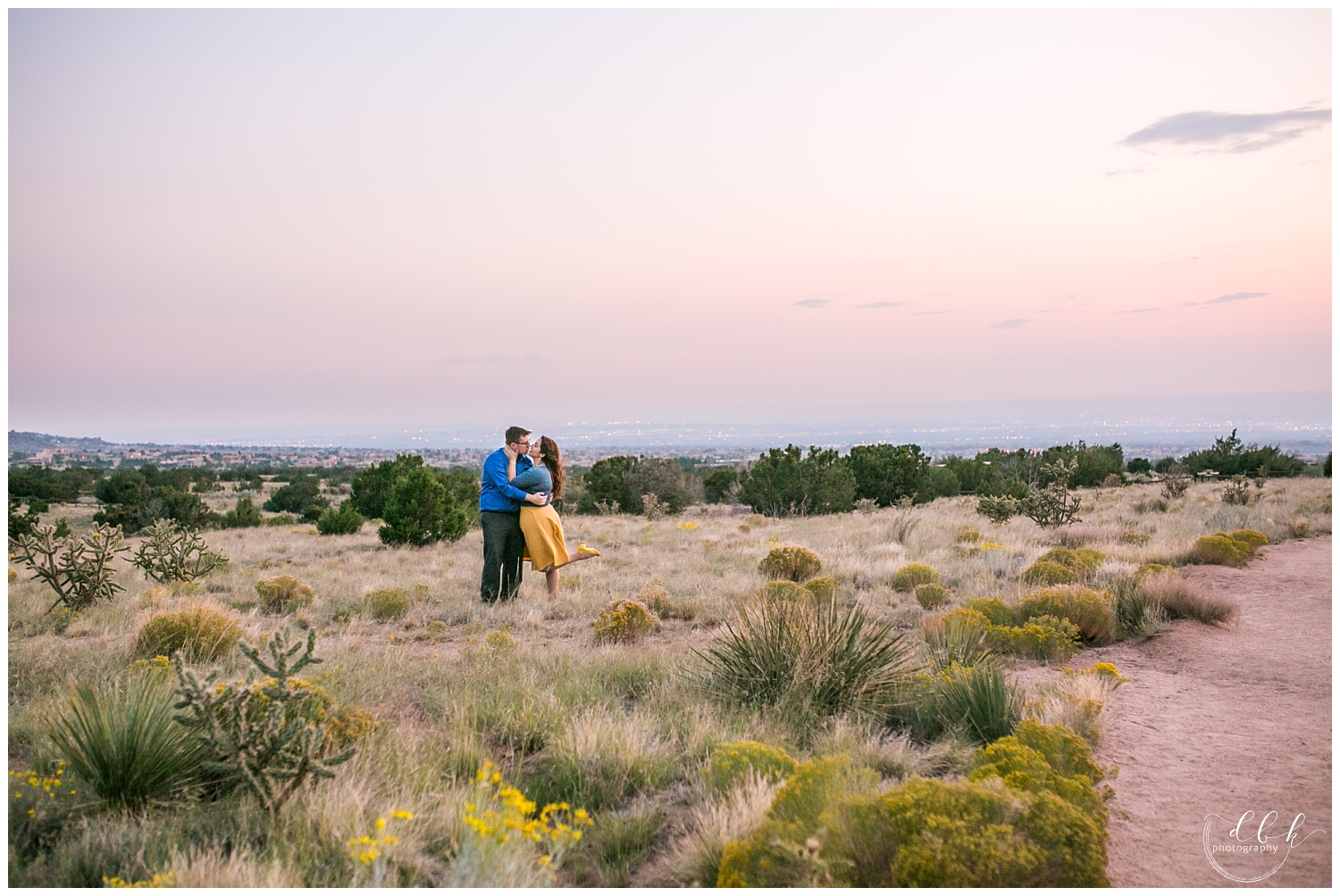 wide shot of couple kissing in the desert at sunset in Albuquerque, New Mexico