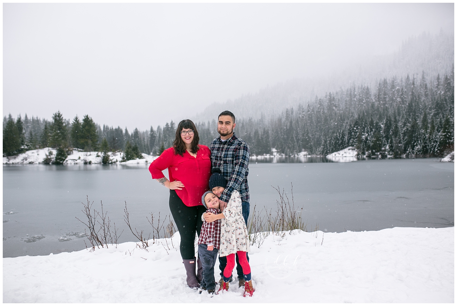 family dressed in red posing for portraits at Gold Creek Pond, Washington