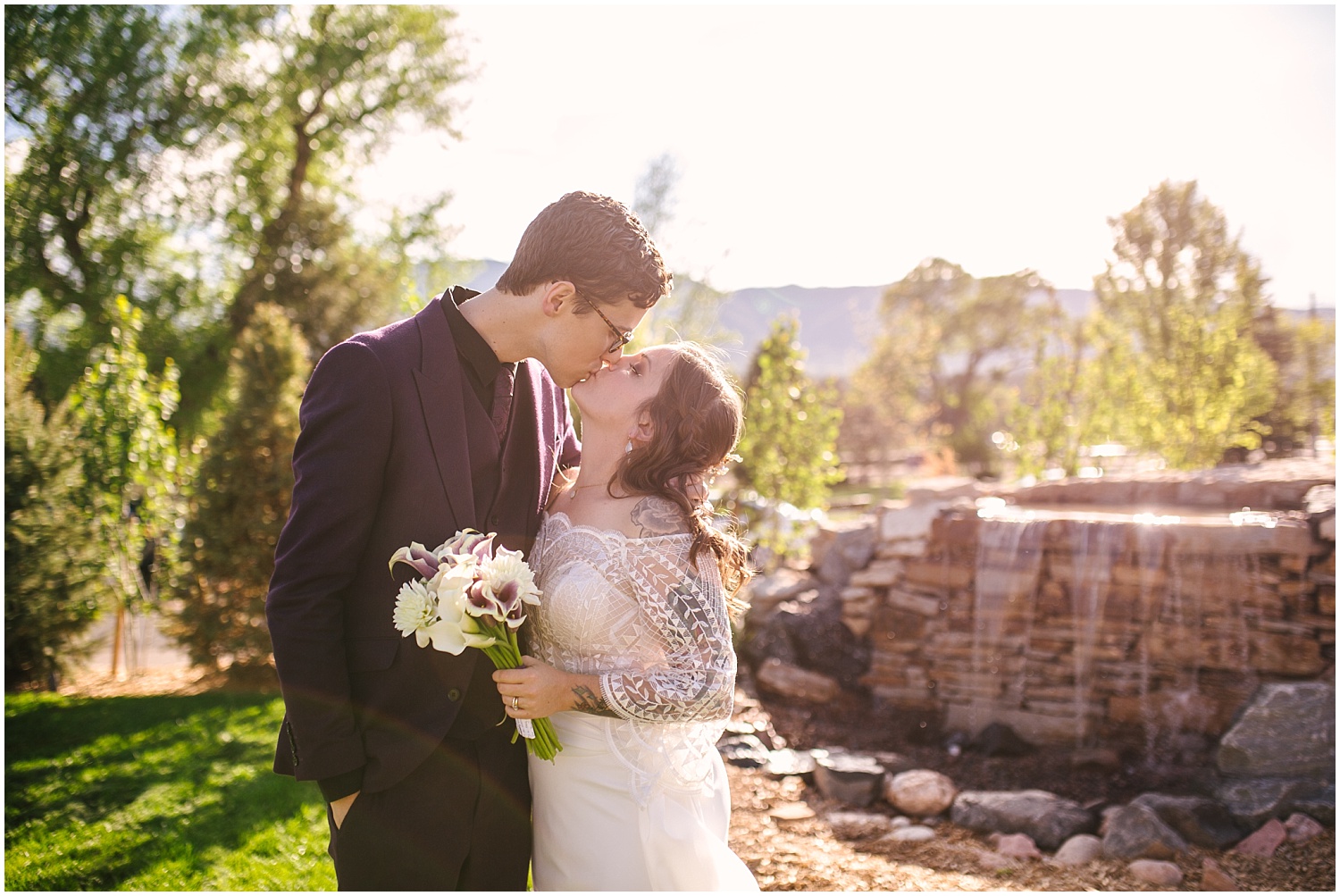 Bride and groom kissing on the lawn at Hearth House Venue wedding in Monument, Colorado