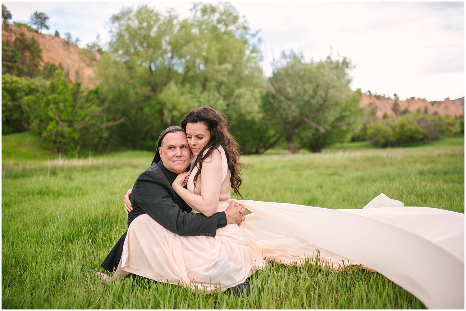 Couple cuddling in the grass for Red Rock Canyon Open Space engagement photos in Colorado Springs