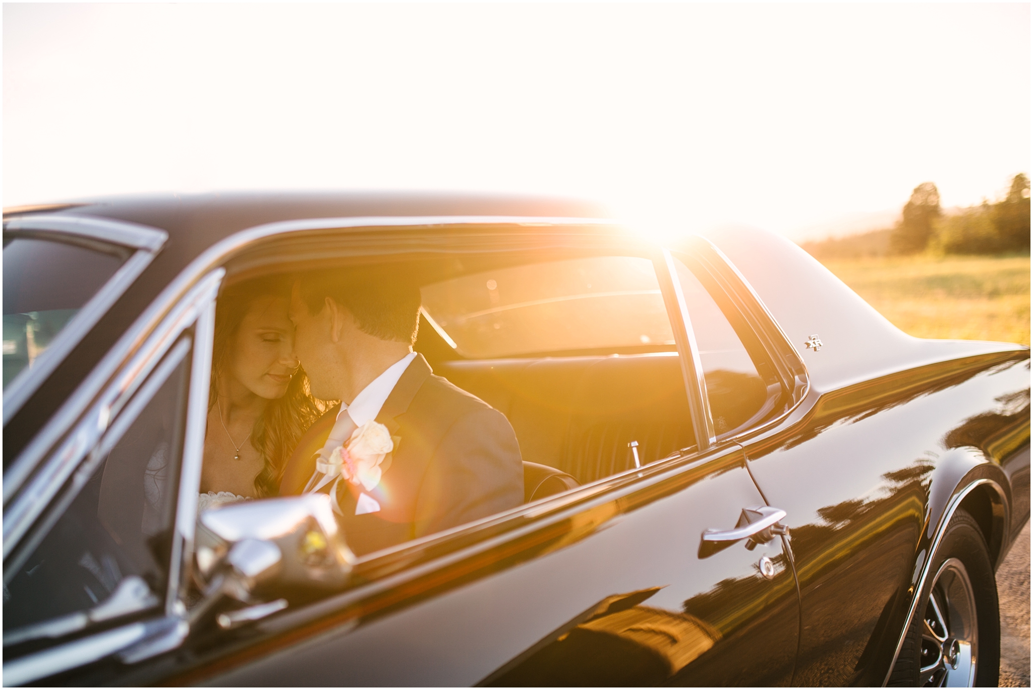 Bride and groom sit in classic car surrounded by golden light at Cle Elum wedding