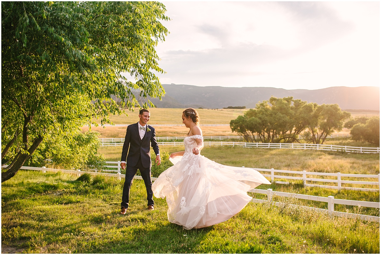 Bride and groom dance together at sunset overlooking the fields surrounding Crooked Willow Farms