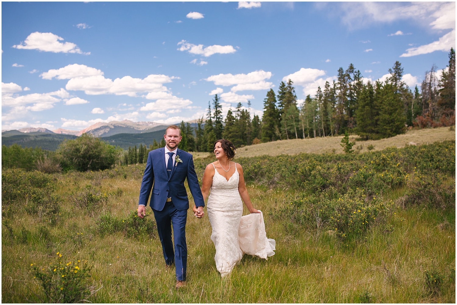 Bride and groom walking through a field in Kenosha Pass Colorado