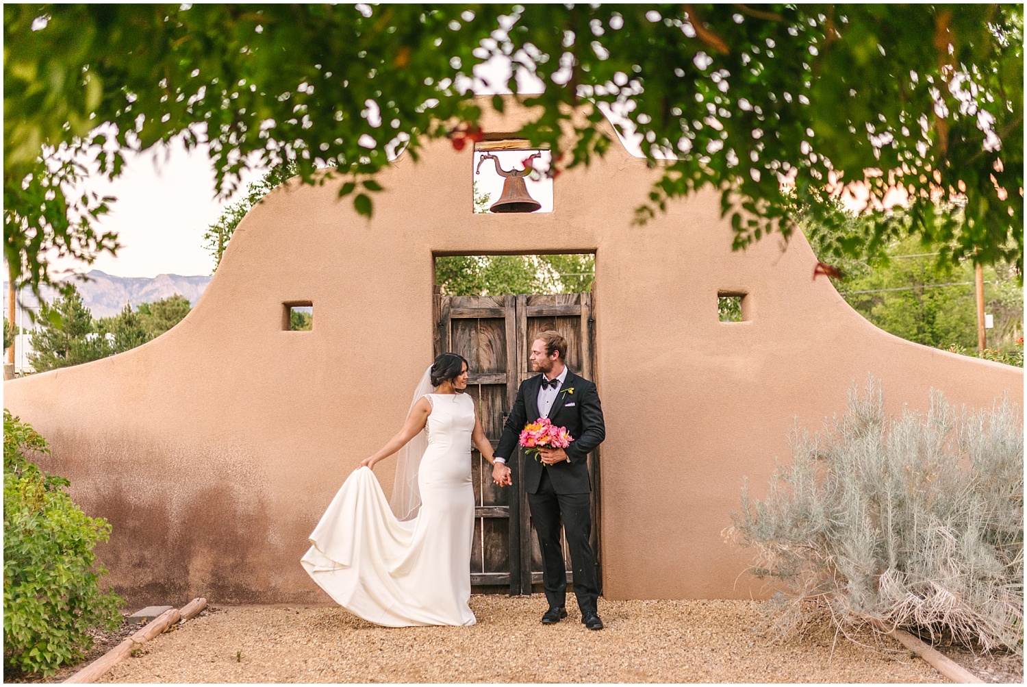 Bride and groom hold hands by the gate at Casa Perea Art Space wedding venue in Corrales