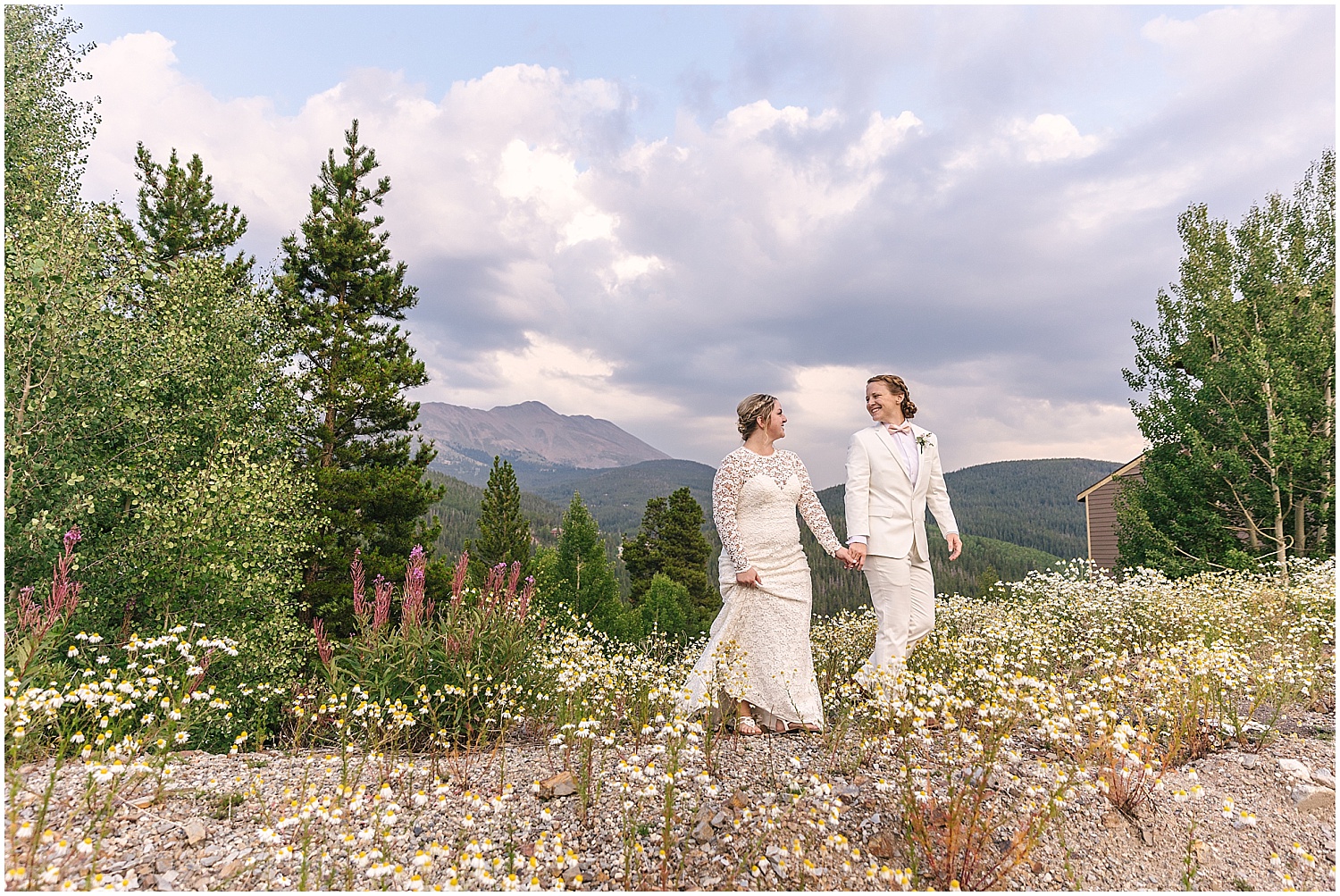 Two brides walking in a field of flowers at Breckenridge wedding venue