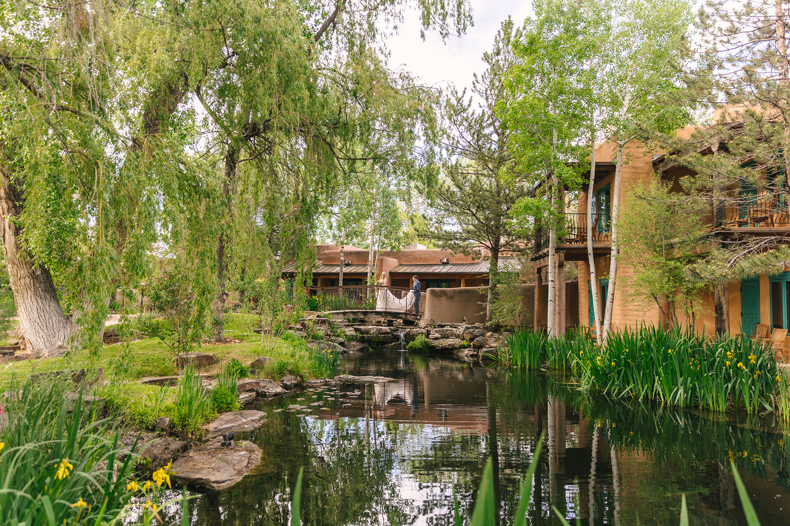 bride and groom walking over bridge at the green El Monte Sagrado wedding venue